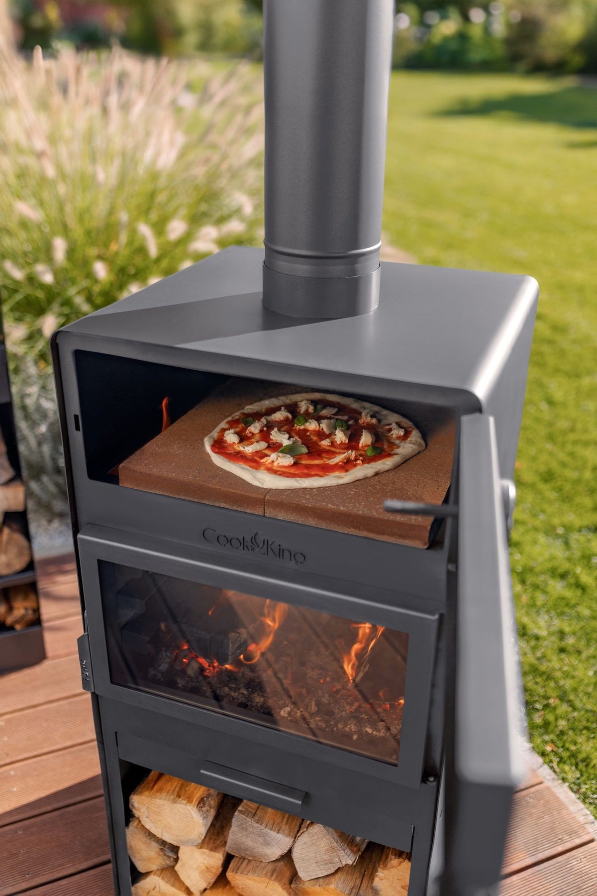 Cook King – Pack VENTO – Brasero cheminée avec four, grille de cuisson et range-bûches — mise en situation