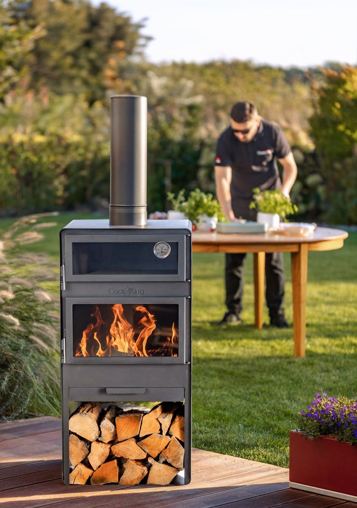 Cook King – Pack VENTO – Brasero cheminée avec four, grille de cuisson et range-bûches — mise en situation