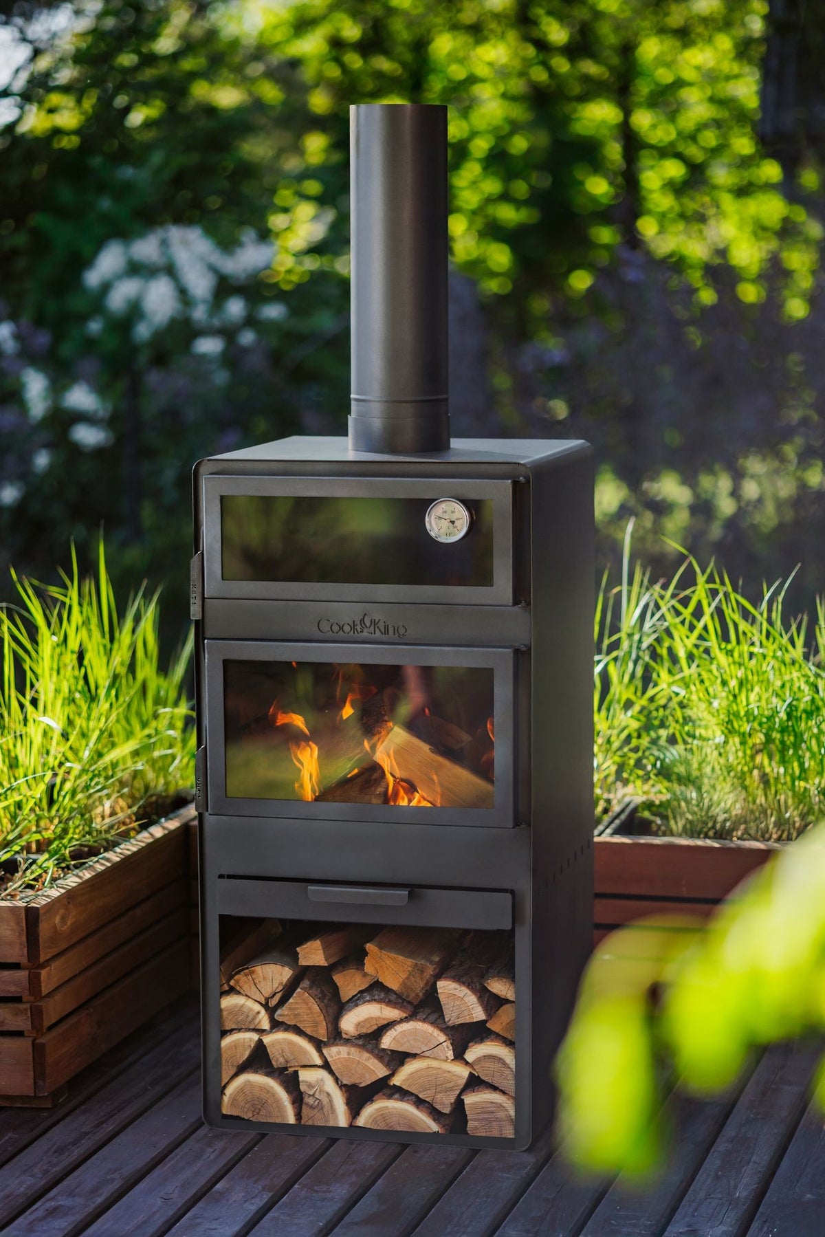 Cook King – Pack VENTO – Brasero cheminée avec four, grille de cuisson et range-bûches — mise en situation
