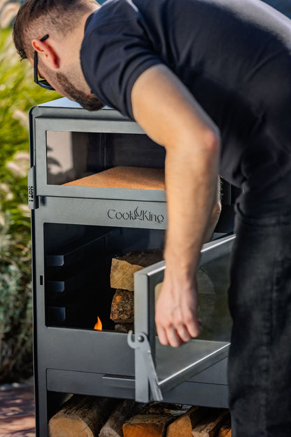 Cook King – Pack VENTO – Brasero cheminée avec four, grille de cuisson et range-bûches — mise en situation