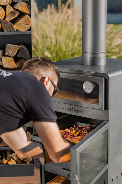 Cook King – Pack VENTO – Brasero cheminée avec four, grille de cuisson et range-bûches — mise en situation
